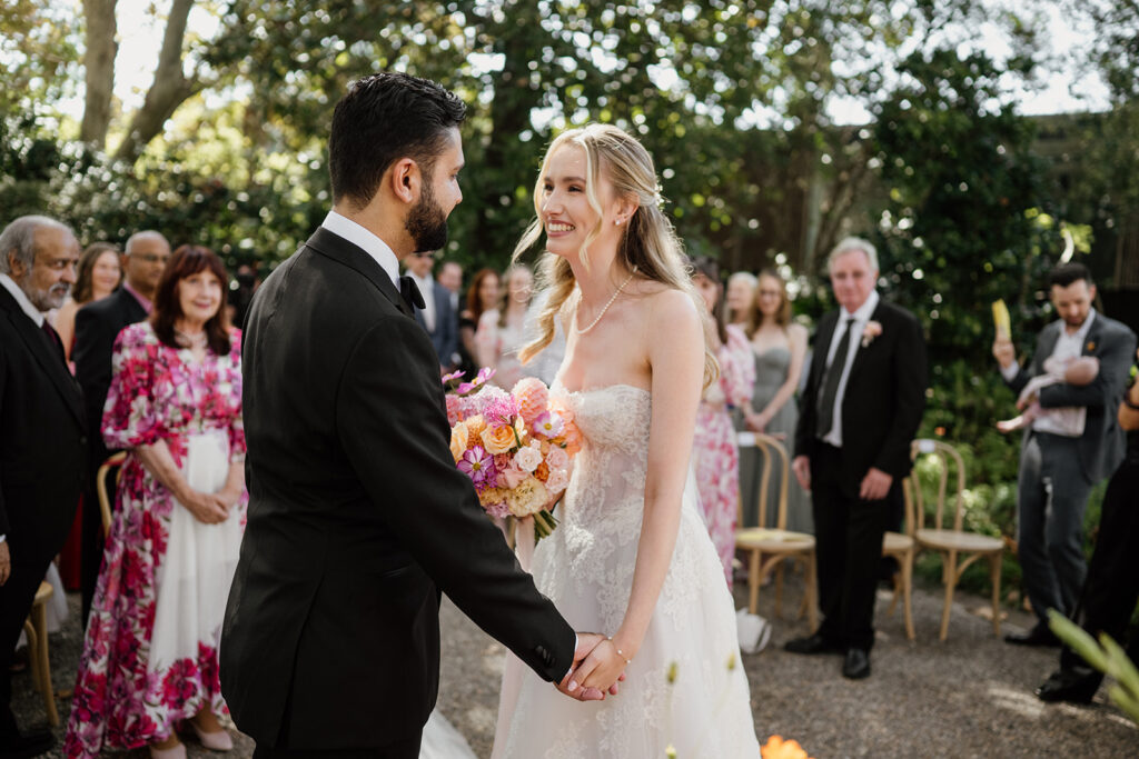 The bride and groom exchange smiles during the wedding ceremony at Lindesay House in Sydney, by wedding photographer Scott Surplice